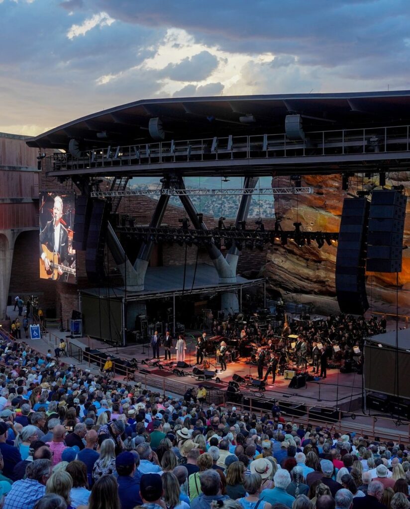 We’re counting down the days until Lyle Lovett returns for an incredible 25th appearance on July 9! A 2018 Red Rocks Hall of Fame inductee, Lyle first stepped onto our stage (and into our hearts) in 1990 before returning to headline with his Large Band in 1992, establishing himself as a Red Rocks regular ever since. Stroll down memory lane:🤵 Playing his 13th show in 2007 – a co-headline with K.D. Lang
🎉 Backstage with one of his many his Piece of the Rock Awards in 2005
🎻 His Large Band got even larger in 2023, appearing with the Colorado Symphony
📆 See you in two weeks